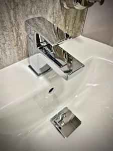 a white bathroom sink with a chrome faucet at The Gun at Ridsdale in Ridsdale