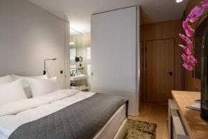 a bedroom with a large white bed and a desk at Zlata Ladjica Boutique Hotel in Ljubljana