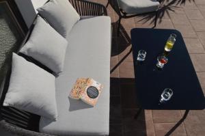 a white couch with a table with a glass of wine at Apartment Pyrus in Tirolo +11 photos