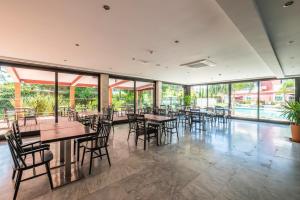 een restaurant met tafels, stoelen en ramen bij Topazio Vibe Beach Hotel & Apartments - Adults Friendly in Albufeira