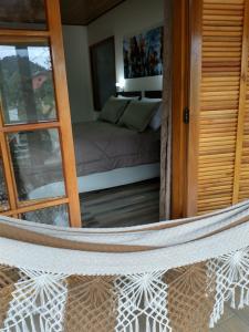 a view of a room with a bed through a mirror at Chalés do Pardal in Visconde De Maua