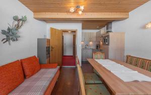 a dining room with a table and a kitchen at Pension Bartlhof in Lermoos