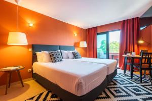 a hotel room with a bed and a balcony at Topazio Vibe Beach Hotel & Apartments - Adults Friendly in Albufeira
