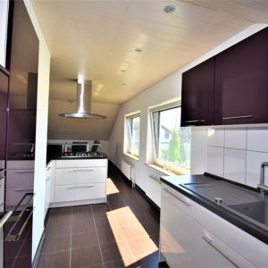 a large kitchen with white cabinets and black counter tops at FeWo 4 - Erpolzheim in Erpolzheim