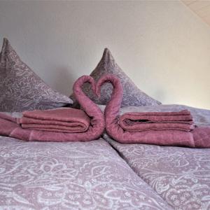 two pink flamingos towels sitting on top of a bed at FeWo 4 - Erpolzheim in Erpolzheim