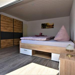ein Schlafzimmer mit einem großen Bett mit rosa Kissen in der Unterkunft FeWo 4 - Erpolzheim in Erpolzheim + 2 Fotos