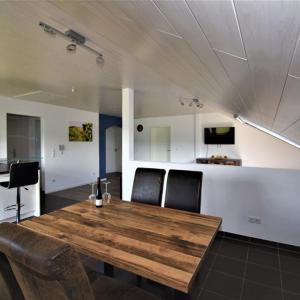 ein Esszimmer mit einem Holztisch und Stühlen in der Unterkunft FeWo 4 - Erpolzheim in Erpolzheim