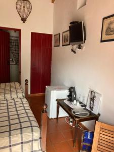 a bedroom with a bed and a table and a television at Quarto em Monte Alentejano perto do Cercal in Cercal +13 photos