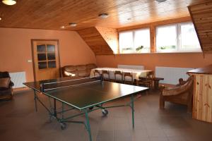 - une table de ping-pong dans une pièce avec des chaises dans l'établissement Dom na skarpie - domek z kominkiem, à Dąbrówka