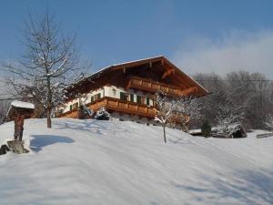 una casa en la nieve delante en Ferienwohnungen Oberthannlehen, en Bischofswiesen