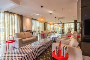 アルブフェイラにあるTopazio Vibe Beach Hotel & Apartments - Adults Friendlyのホテルのロビー(ソファ、テーブル、椅子付)