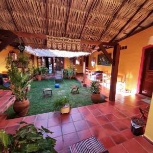 a living room with plants and a ceiling at Manga Rosa Hospedagem in Canoa Quebrada