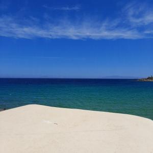 a sandy beach with the ocean in the background at Paroscarmel studio-apartment in Logaras