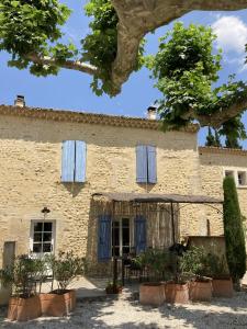 an old stone house with blue shuttered windows at Les Lavandes in Tulette