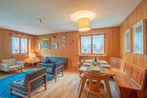 un soggiorno con un tavolo e un divano di APPARTAMENTO CAMILLE - Accogliente appartamento - COUR 0078 a Courmayeur