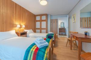 una camera d'albergo con due letti e una scrivania di APPARTAMENTO CAMILLE - Accogliente appartamento - COUR 0078 a Courmayeur