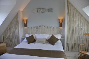 een slaapkamer met een groot wit bed met een houten hoofdeinde bij Céleste In in Port-Louis