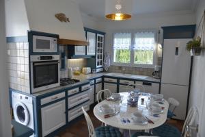 een keuken met een tafel en een fornuis bovenste oven bij Céleste In in Port-Louis