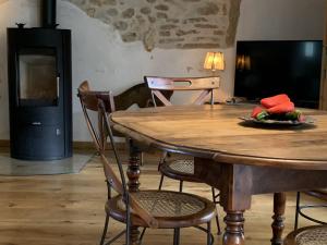a dining room with a table and chairs and a television at Les Lavandes in Tulette