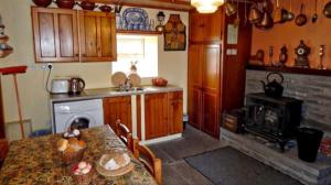 uma cozinha com uma mesa e um fogão em The Cosy Barn em Kilrush