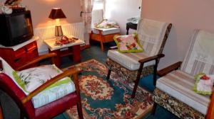 a living room with two chairs and a tv at The Cosy Barn in Kilrush