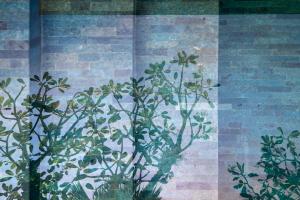 a mural of plants on the side of a brick wall at Blossom Eco Luxe Villas by Ekosistem in Canggu