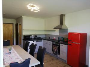 a kitchen with a red refrigerator and a table with chairs at Ferienwohnung "beim Hirsch" Bregenzerwald in Langenegg