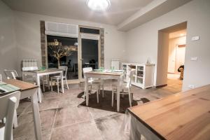 a dining room with white tables and white chairs at La Casa Tra Gli Ulivi in Assisi