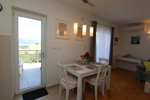 - une cuisine et une salle à manger avec une table et des chaises dans l'établissement Apartment SKVICALO, à Šilo