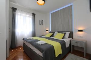 - une chambre avec un grand lit et des oreillers jaunes dans l'établissement Apartment SKVICALO, à Šilo