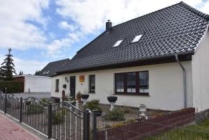 ein weißes Haus mit einem schwarzen Dach in der Unterkunft Karlshagen - Lissis Feriendomizil in Ostseebad Karlshagen