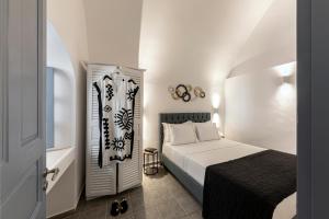 a small bedroom with a bed and a bathroom at Caldera Senses in Fira
