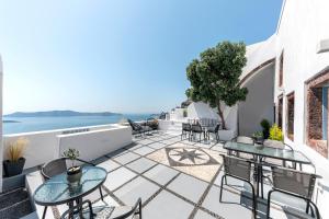 a patio with tables and chairs overlooking the ocean at Caldera Senses in Fira
