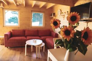 a living room with a couch and a table with sunflowers at Słoneczny Zagajnik-domek na skraju lasu, Roztocze, Zwierzyniec in Lipowiec