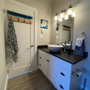 a bathroom with a sink and a mirror at Port Renfrew Oceanfront Retreat in Port Renfrew