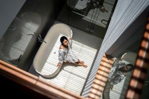 a woman standing in front of a mirror in a bath tub at Blossom Eco Luxe Villas by Ekosistem in Canggu