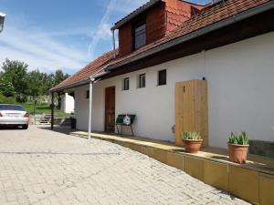 Biały dom z doniczkami na boku w obiekcie Ferienhaus Weingarten Eisenberg w mieście Vaskeresztes