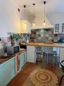 a kitchen with white cabinets and a table with chairs at Villa Rosa Boutique in Almancil