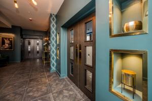 Stay Hotel في هدرسفيلد: مدخل مع جدران زرقاء وأبواب وأرضيات من البلاط
