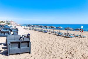 - une rangée de chaises et de parasols sur une plage dans l'établissement Viñamar La Mata, à La Mata