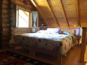 a bed in a log cabin with a window at B&B Le Corone - Chalet nel Bosco in Cavalo