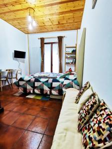 Un dormitorio con una cama y un sofá. en GranChalet sul Cimone 103, en Montecreto