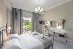 ein Schlafzimmer mit einem Bett, einem Schreibtisch und einem Spiegel in der Unterkunft Erofili Hotel in Kavos