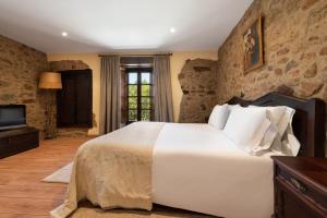 een slaapkamer met een groot wit bed en een televisie bij Pazo de Moreda in Sober +30 foto's