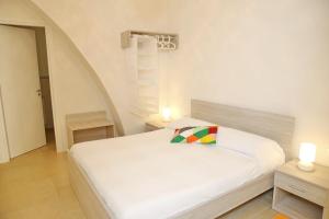 カステッランマーレ・デル・ゴルフォにあるM&R Casa Vacanze Via Alberto Marioの白いベッド1台(カラフルな枕付)