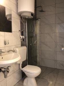 een badkamer met een toilet, een wastafel en een douche bij Guesthouse Adriatic in Biograd na Moru
