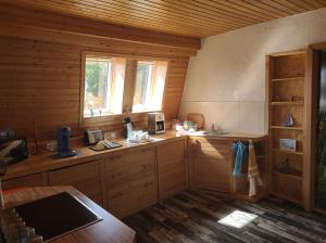 - une cuisine avec des placards en bois et une fenêtre dans une cabine dans l'établissement Ferienwohnung Nixe, à Sandstedt
