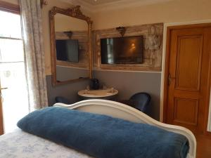 Schlafzimmer mit einem Bett, einem Spiegel und einem Waschbecken in der Unterkunft La Marlottine in Bourron-Marlotte