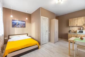 モスクワにあるFoRRest Vodnyのベッドルーム(黄色いベッド1台付)、キッチンが備わります。