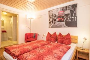 a bedroom with a red bed and a double decker bus at Haus Sonnenschein Gartentraum in Bermatingen